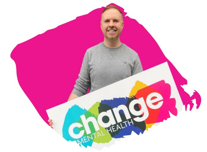 Man holding Change Mental Health logo banner with pink background