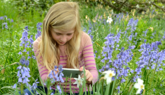 Young girl viewing plants through a mobile phone