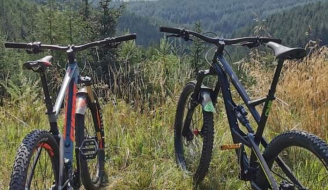 Two bicycles propped up in rural setting