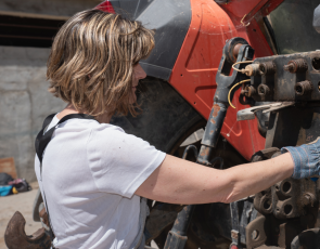 Woman mechanic repairing a tractor outdoors by Joe_McUbed (Canva)