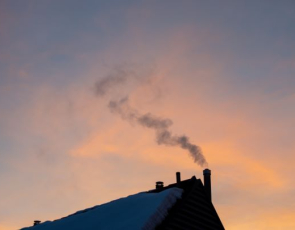 orange wintery sky with snow covered roof in foreground