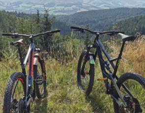 Two bicycles propped up in rural setting