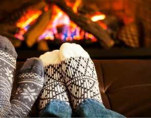 Two people warming their feet by a fire