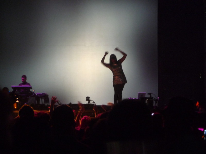 Dancer silhouetted on stage in front of audience