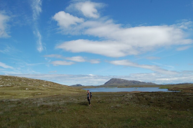 Walker with backdrop of sea loch and hill