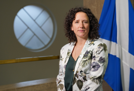 Cabinet Secretary for Rural Affairs, Land Reform and Islands, Mairi Gougeon standing in front of Saltire flag