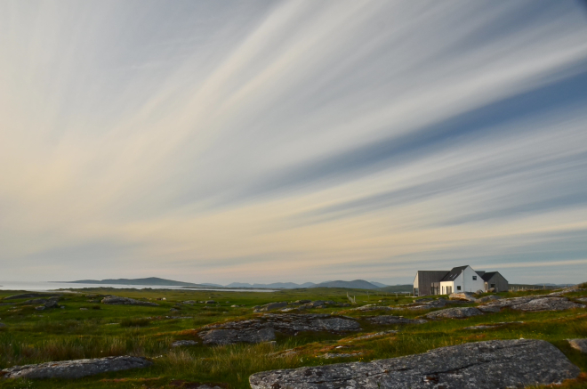 View of open country in North Uist with house in the distance