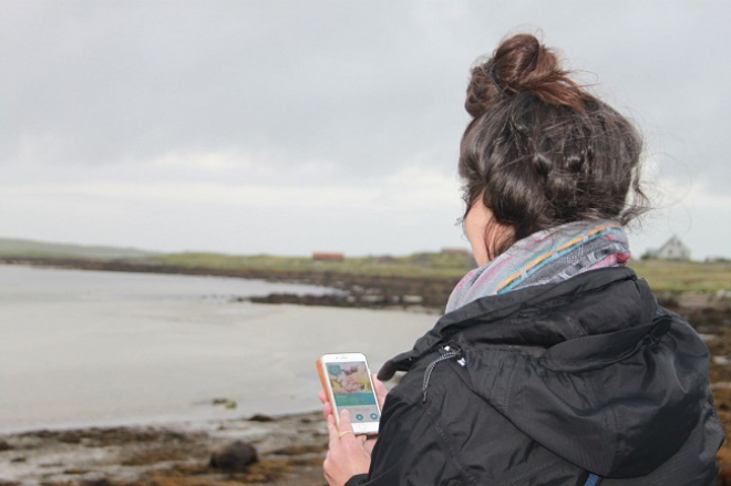 Woman using app on phone beside water