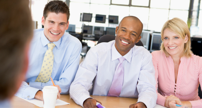 Three people smiling on an interview panel