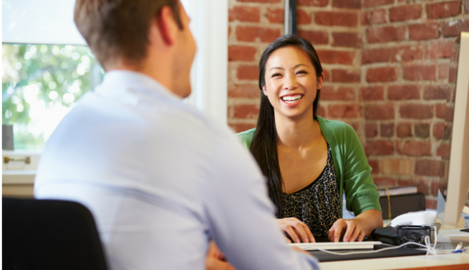 woman sitting across desk from man