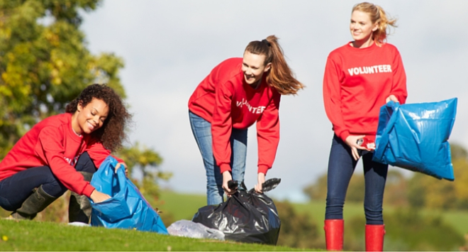 Three women picking up litter