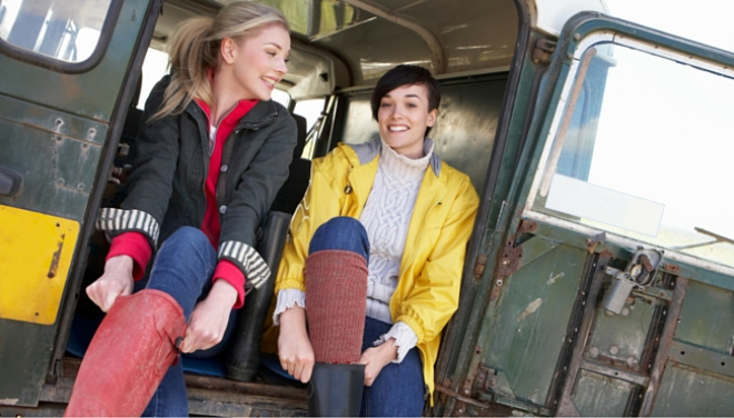 Woman in wellies sitting in back of landrover