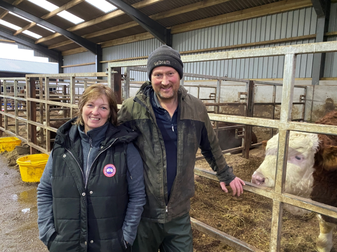 Female and male farmer beside livestock on a farm