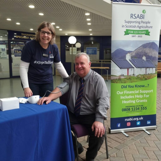 RSABI worker with farmer at table