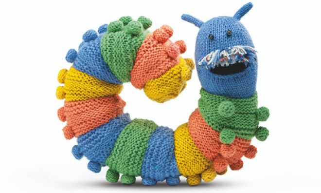 Knitted multicoloured caterpillar draft excluder smiling