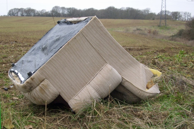 Flytipped armchair in a field 