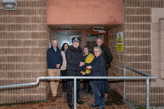 Chief Inspector Jamie Wilson shakes hands with Joan Bishop, Chair DACIC. In back row left to right: Gordon Sutherland, Secretary DACIC, Catherine Moodie, Community Development Manager DACIC, Liz Howard Development Manager Highlands & Islands Enterprise and Scottish Land Fund, Iain Levens, Levens Studio  