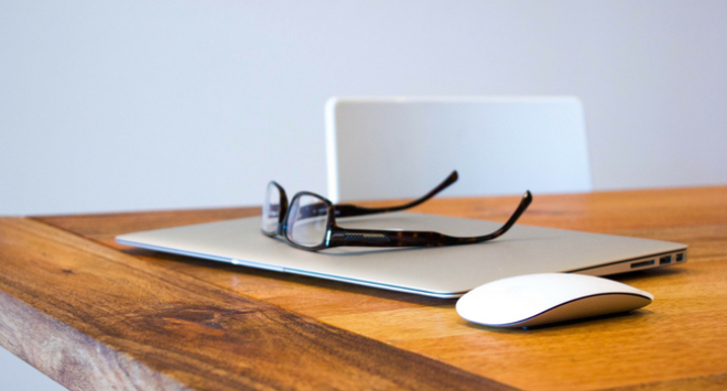 glasses and laptop on a desk 