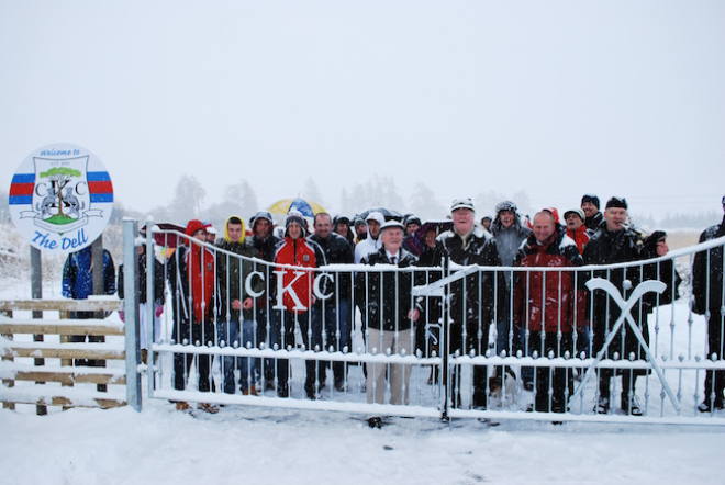 Group photo of people in the snow at the opening of Kingussie Shinty Club pitch