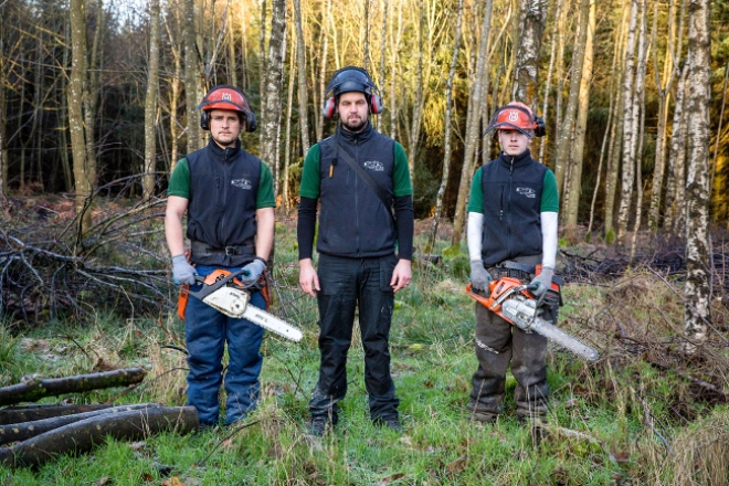 Three men in forest with chainsaws