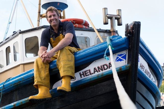 Fisherman sitting on side of boat