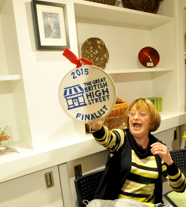 Woman holding up Great British high Street award