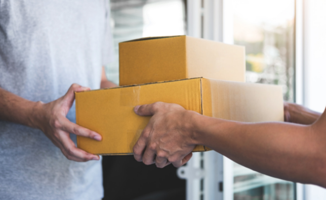 Man handing two parcels to other man