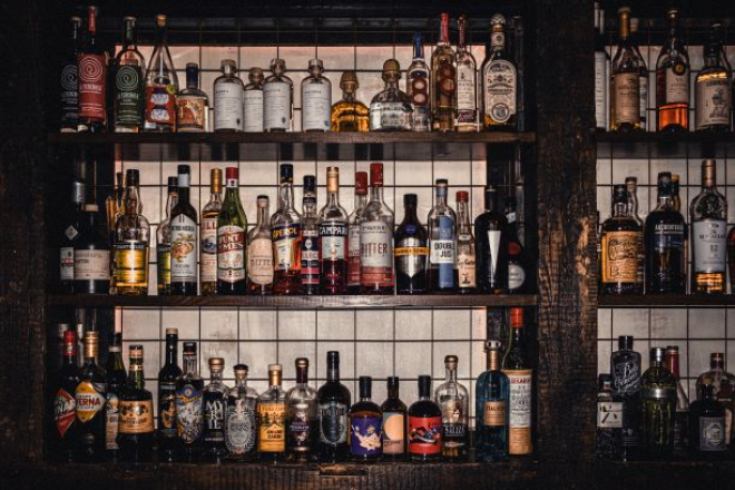 Shelves of alcohol behind a bar