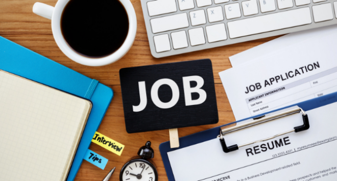 job written in middle of picture, surrounded by file, coffee, keyboard, resume and job applications