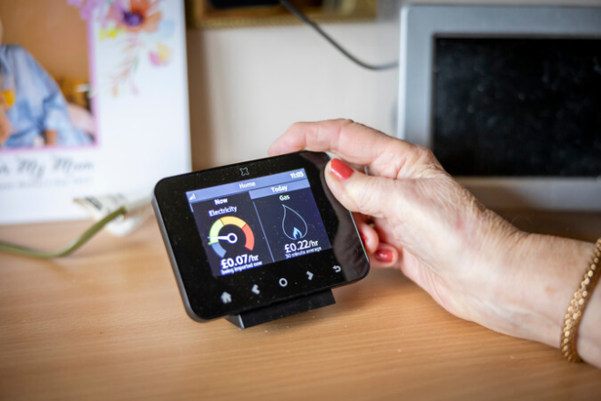 Woman adjusting smart meter. Photo credit:ageing-better.org.uk