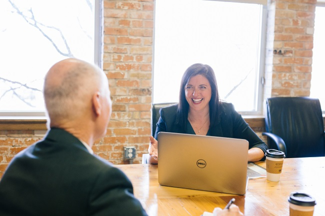 woman sitting across desk from man