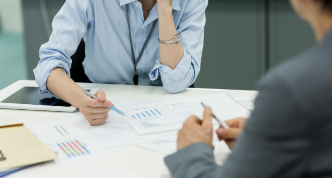 Two people in business meeting with papers