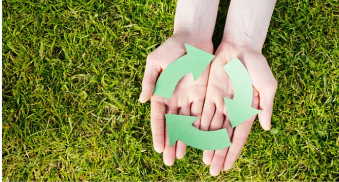 hands holding paper recycling sign