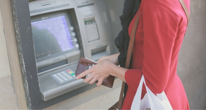 young woman using cash machine