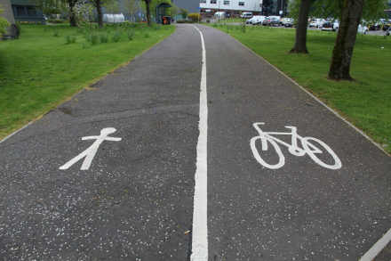 Cycle path divided by thick white line with image of stick person on one side and a bike on the other