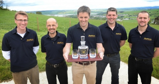 Picture of 5 men holding a whisky decanter and glasses with distilery name engraved on the glassware