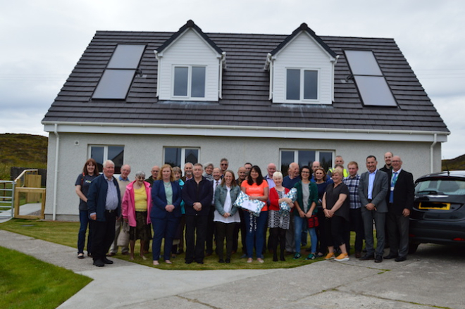 participants in house warming event standing outside the houses