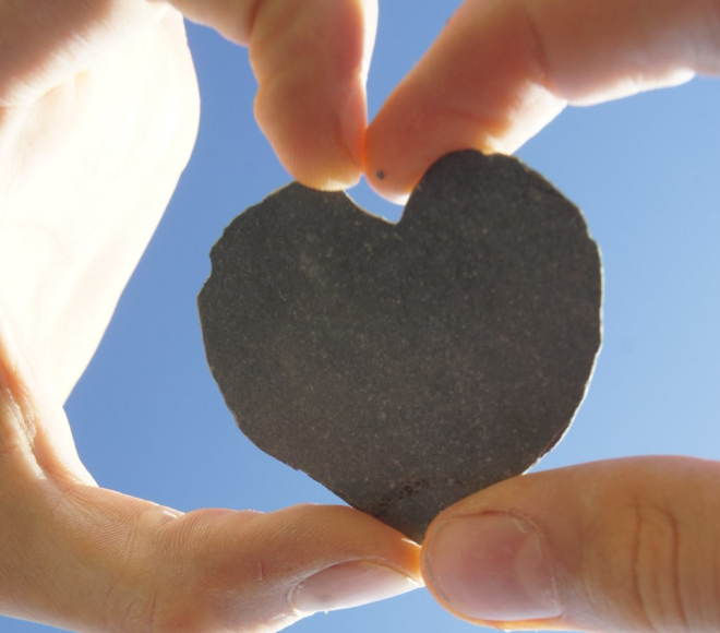 Small heart-shaped stone held between hands