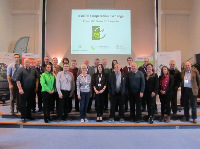 photo of event attendees standing on a stage 