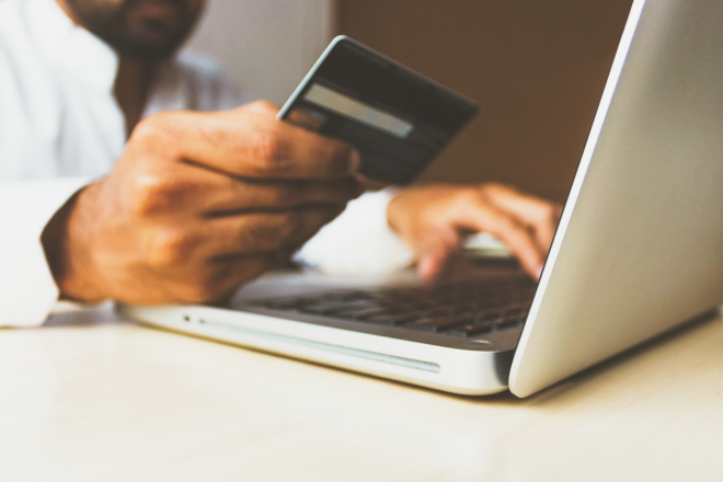 Man shopping online holding credit card