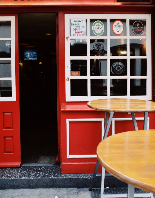 Red pub with two round tables outside