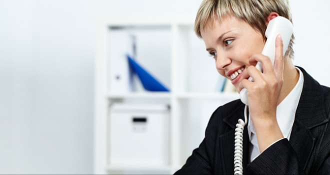 woman at desk using phone