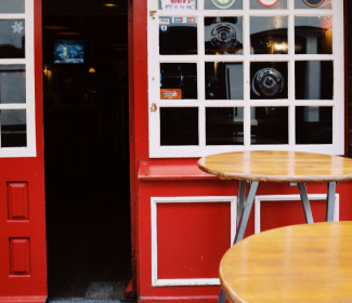 Red pub with two round tables outside